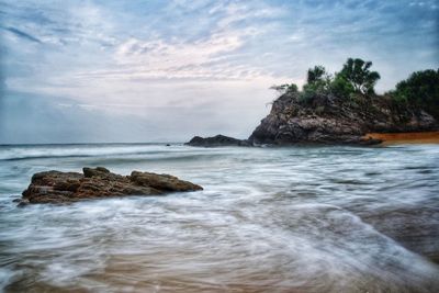 Scenic view of rocks in sea against sky