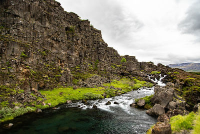 Scenic view of waterfall against sky