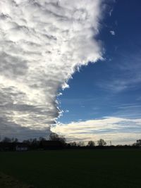 Scenic view of field against cloudy sky