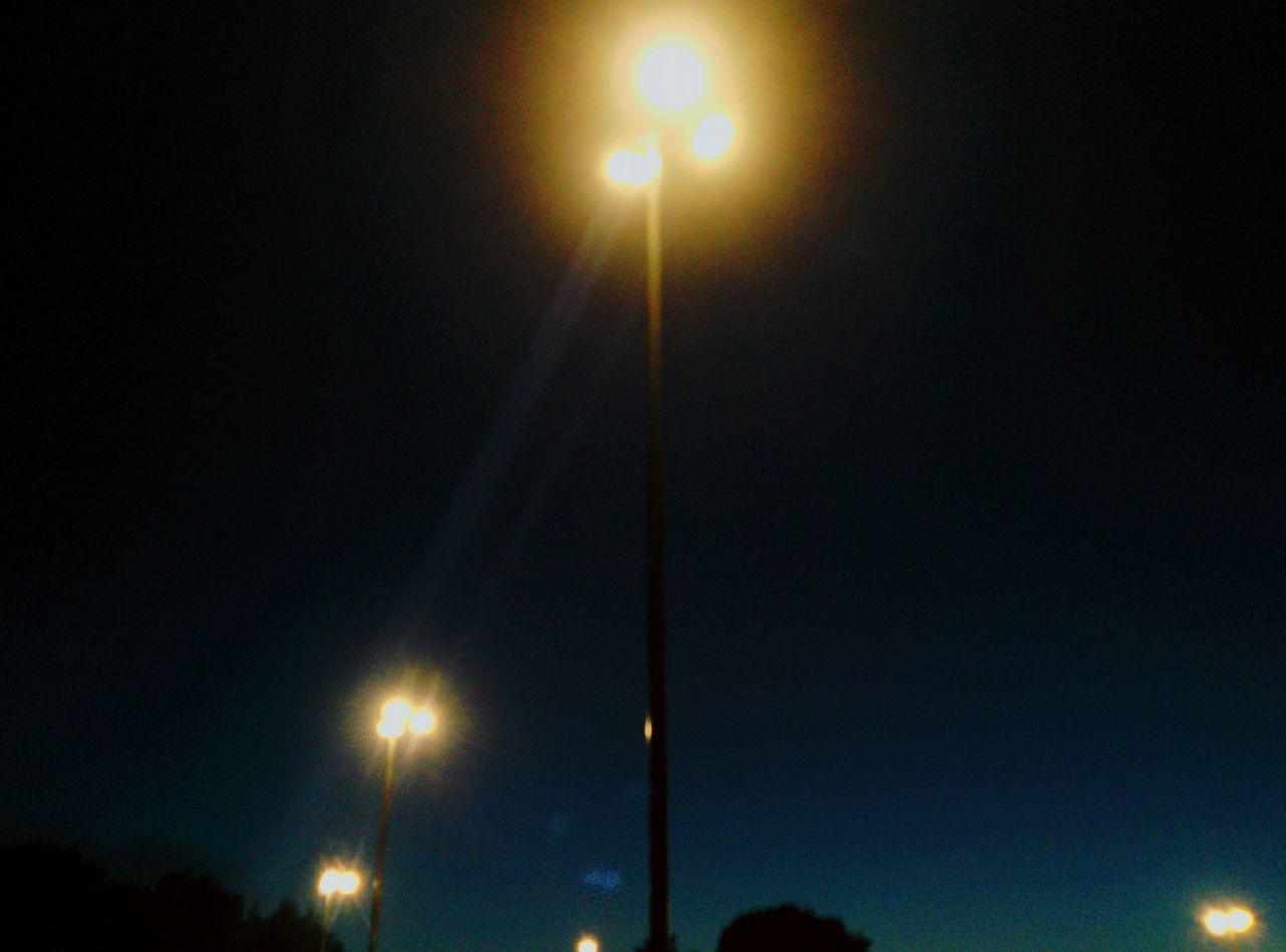 night, illuminated, low angle view, street light, lighting equipment, electricity, dark, sky, glowing, electric light, outdoors, lit, no people, light, light beam, pole, nature, tranquility, beauty in nature