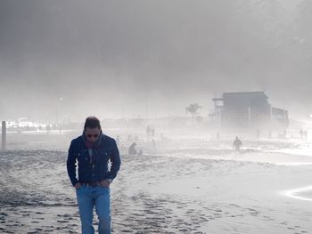 Full length of man standing in snow against sky