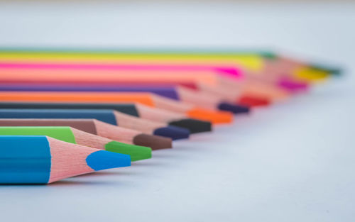 Close-up of colored pencils on white table