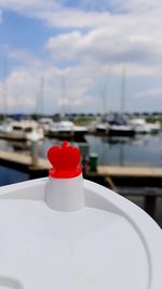 Close-up of red boat moored in sea against sky