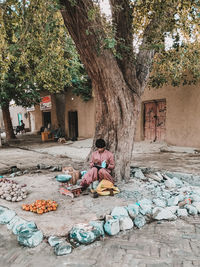Rear view of woman sitting on street