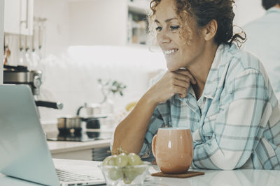 Young woman using mobile phone on table