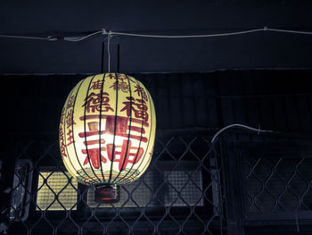 Close-up of illuminated lantern hanging on railing