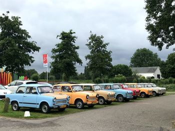 View of cars on road against cloudy sky