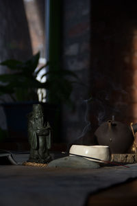 Buddha statue on table by window