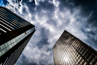 Low angle view of modern building against cloudy sky