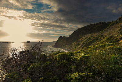 Scenic view of sea and mountains against sky