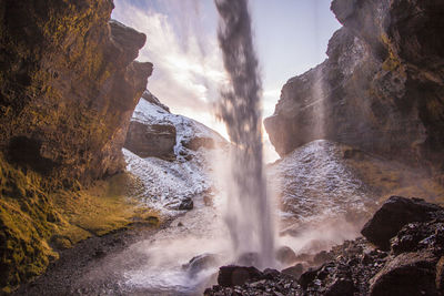 Scenic view of waterfall against sky