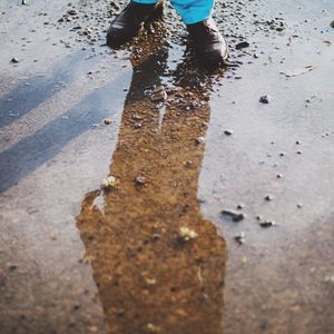 Low section of people standing on wet shore