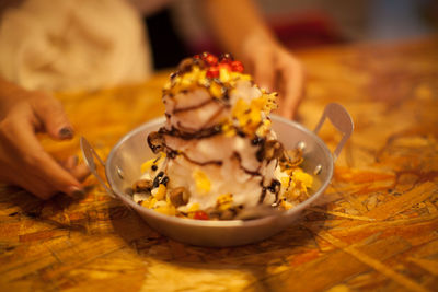 Close-up of ice cream in bowl with woman in background