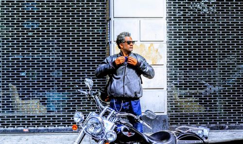 Full length portrait of man standing on motorcycle