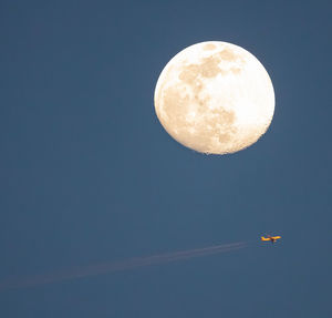 Full moon rising in the east as sun setting in the west making plane have sunlight reflection
