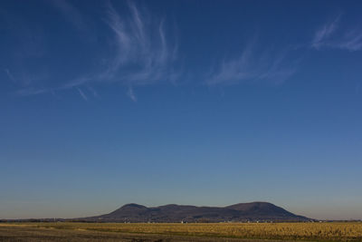 Scenic view of landscape against blue sky