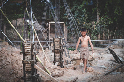 Portrait of shirtless boy standing on land