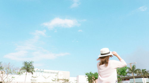 Rear view of woman standing against sky
