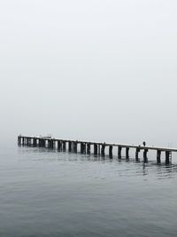 Pier over sea against clear sky