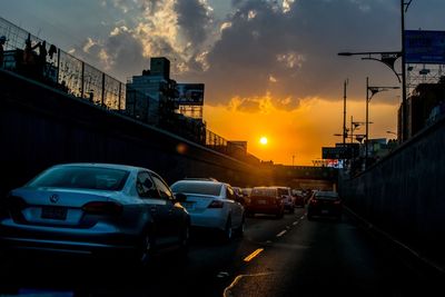 Traffic on road at sunset