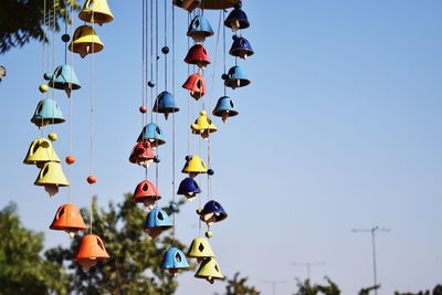 Low angle view of decorative hanging against clear blue sky