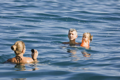 Cheerful family swimming in sea