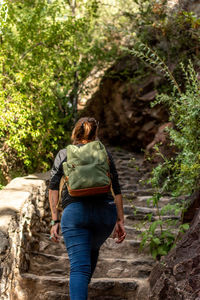 Rear view of woman walking on rock