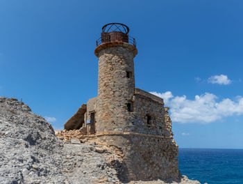 Low angle view of lighthouse by sea against sky