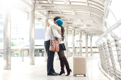 Couple embracing while standing on bridge