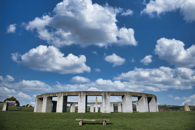 Built structure on field against cloudy sky