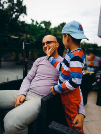 Father with son looking away on seat