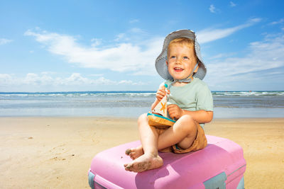 Portrait of young woman sitting at beach