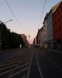 Railroad tracks amidst buildings in city against clear sky