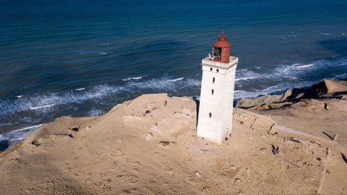 High angle view of lighthouse on beach by sea