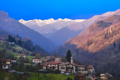 Town by mountains against sky