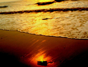 Close-up of silhouette of beach at sunset