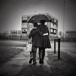 Man walking on umbrella against sky