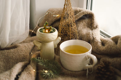 Hot tea, candles, christmas golden balls and decorations. christmas holiday mood