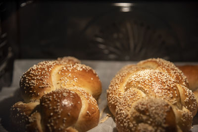 Baking homemade challah bread. braid challah with sesame seeds on a baking sheet in the oven