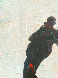 Shadow of man standing on brick wall