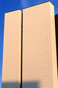 Low angle view of modern building against blue sky