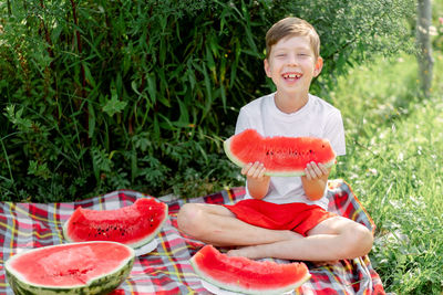 Boy eating watermelon white t-shirt. picnic with watermelons. 