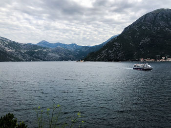 Sailboats in sea against mountains