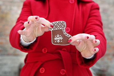 Midsection of woman showing shoe shape cookie during christmas