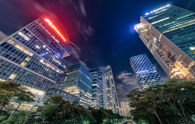 Low angle view of illuminated buildings against sky at night