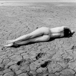 Midsection of woman lying on sand at beach