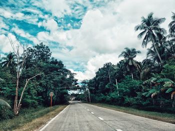 Road amidst trees against sky