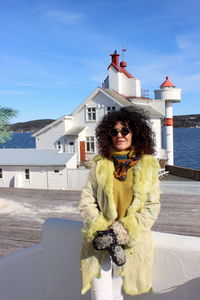 Portrait of woman standing against building