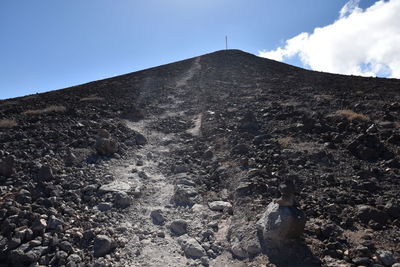 Midsection of woman on rock against sky