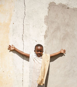 Rear view of a child standing against wall dressed culturally 